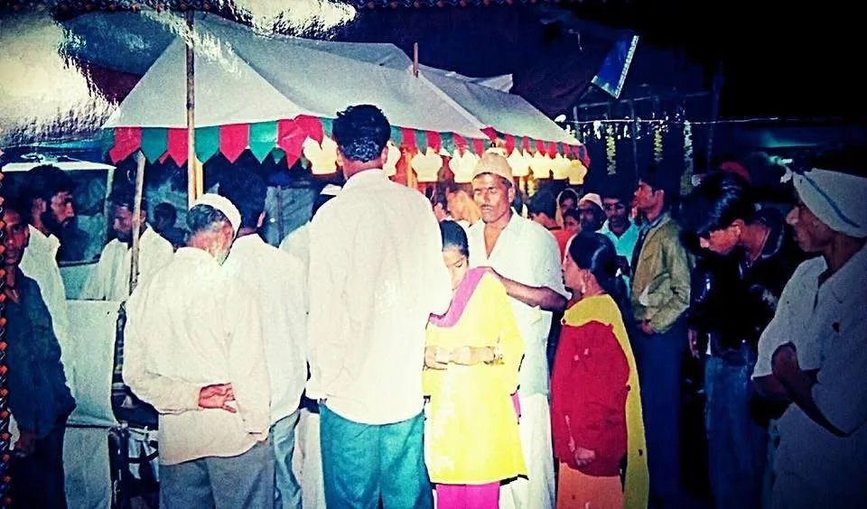 Customers gathered around a Limra stall at night, under a canopy with green and red bunting