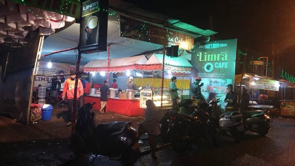 The Limra Café stall at night with a red counter, a glass display and lit Limra signboards